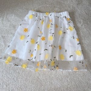 Perfect light skirt for summer and spring. Detailed with yellow flowers.
